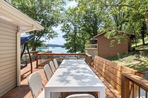 A deck with a table and chairs, overlooking a body of water and trees. - Waterfront House with Private Dock (Rocky Mount)