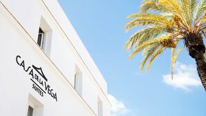 Un bâtiment blanc sur lequel on peut lire l’inscription « Casa de la Vega Suites ».