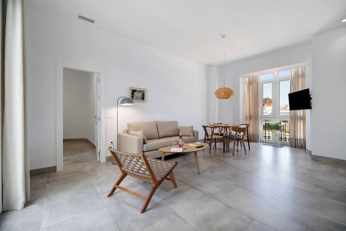 A modern living room with a sofa, coffee table, and wicker chair.