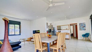 Un espace repas moderne avec une grande table et des chaises, un vase et un canapé.