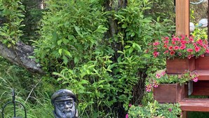 En trädgårdsstaty, en trappa av trä och blomlådor.