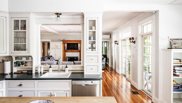 A spacious kitchen with white cabinetry, a black countertop, and a built-in dishwasher. - 2024 Updates Riverfront Home w/ Private Dock Close To Dock Square! Dogs Allowed! (Kennebunk)