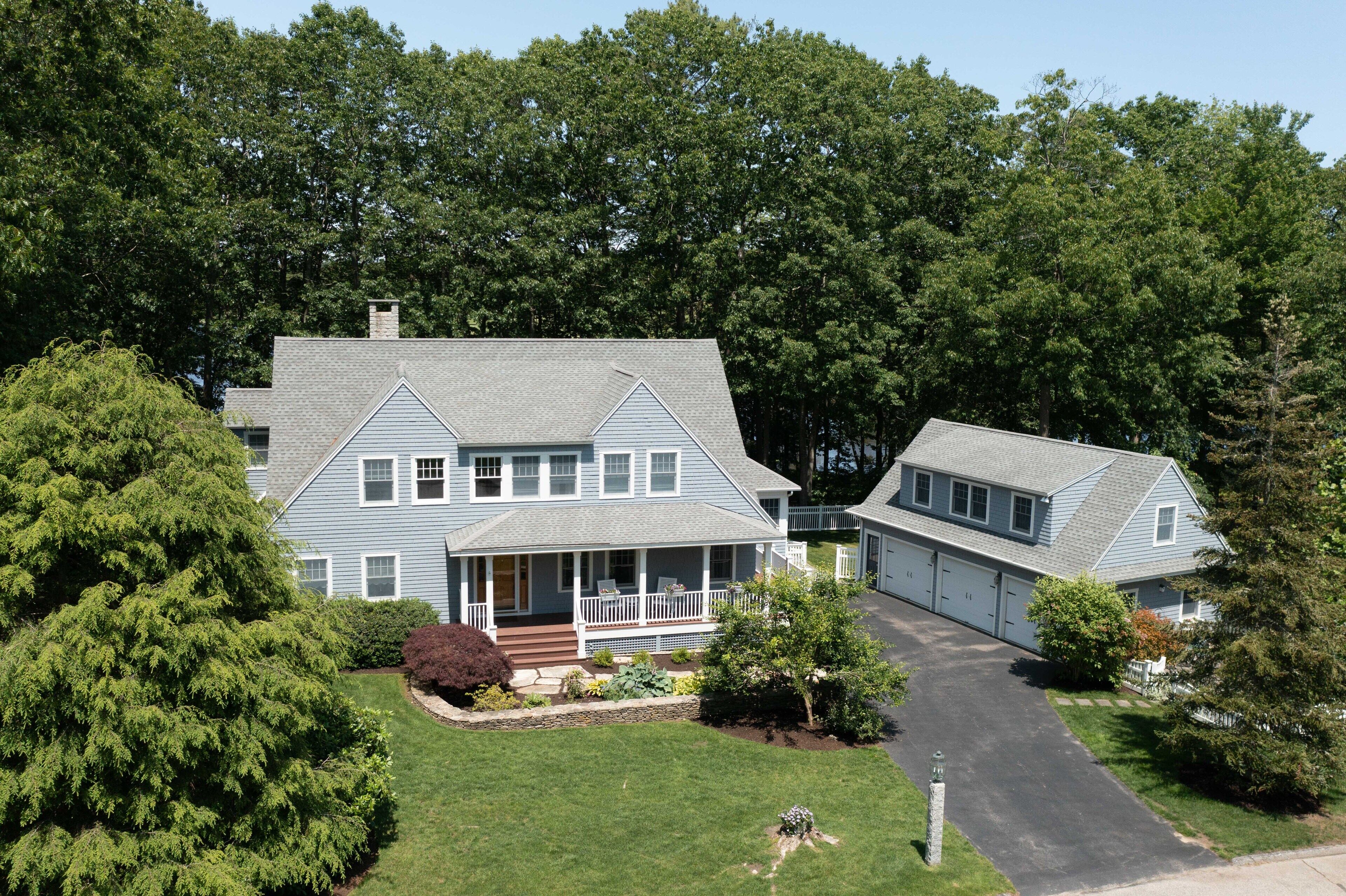 A two-story house with a front porch, a garage, and a well-maintained lawn.