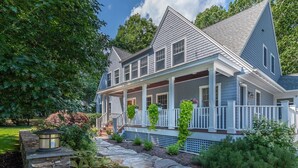 A two-story house with a porch, stone steps, and a stone wall. - 2024 Updates Riverfront Home w/ Private Dock Close To Dock Square! Dogs Allowed! (Kennebunk)