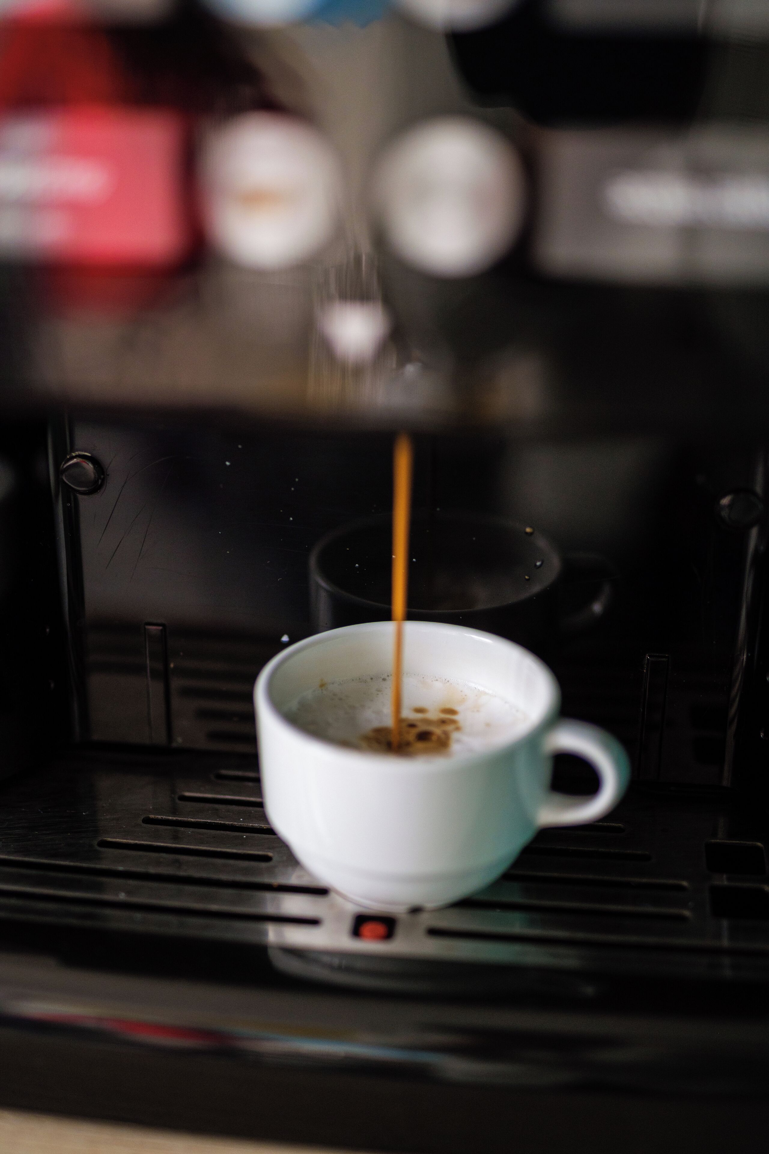 Una macchina del caffè che eroga caffè in una tazza.