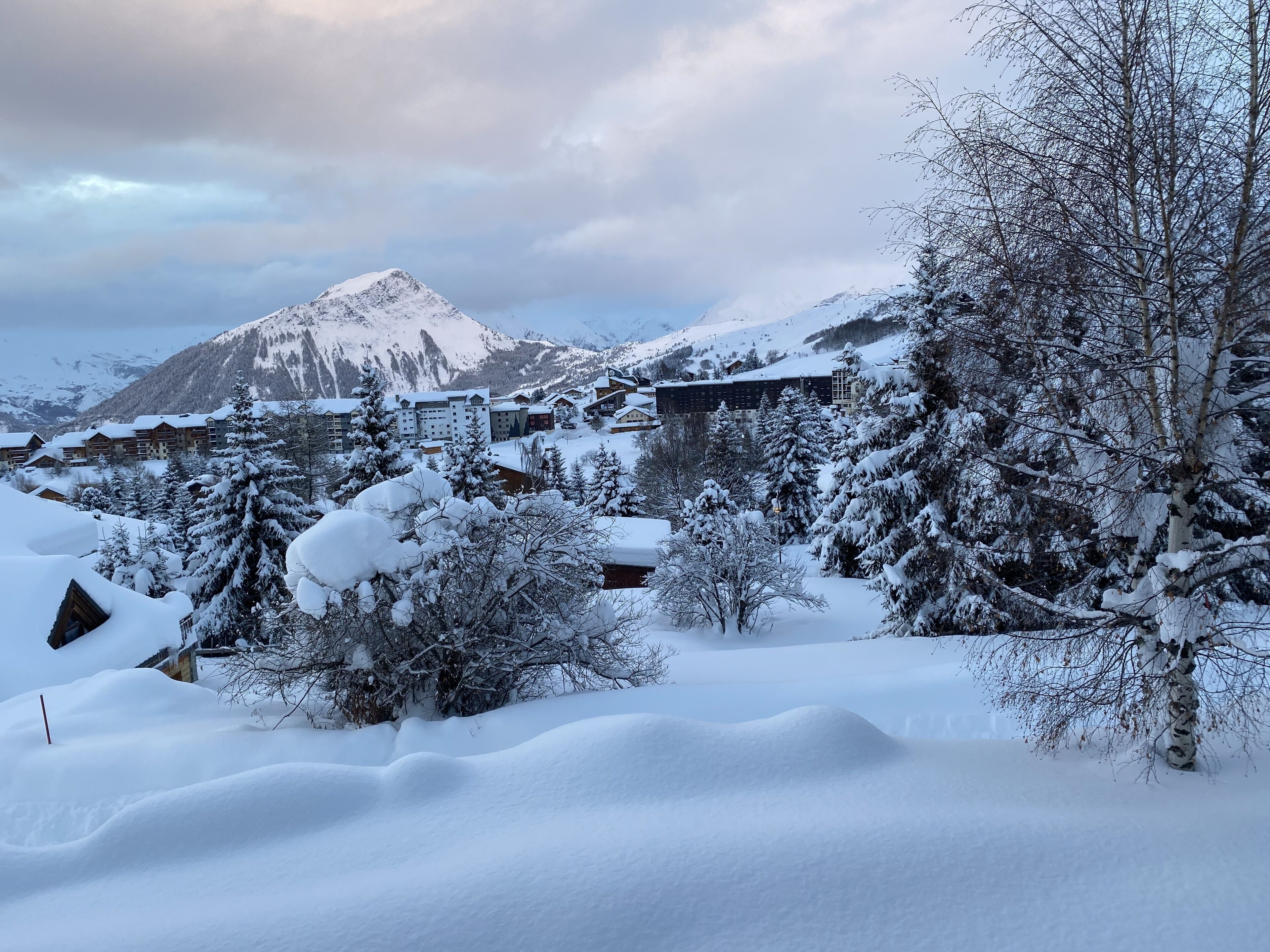 A snow-covered mountain with a lodge in the background.