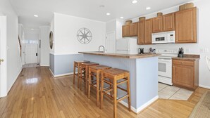 A kitchen with wooden stools, a microwave, and a stove.
