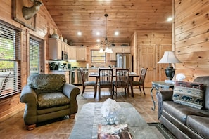 Cozy cabin interior with a dining area, kitchen, and living space, perfect for a relaxing stay.