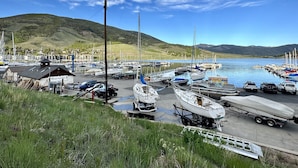 A marina with boats docked, a restrooms building, and a trailer with a boat on it. - Cozy, Modern Lakeside Condo (Dillon)