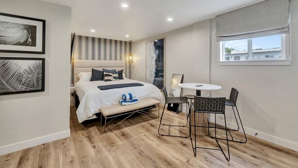 A modern bedroom with a bed, bench, table, and chairs. - Coastal hideaway w/ beach access & workspace (San Clemente)