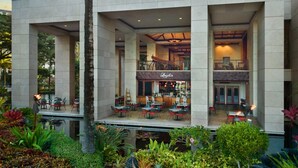 Un hotel moderno con una zona de bar central, terraza y piscina.