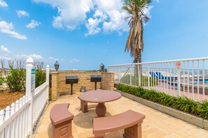Relax by the pool or enjoy a quiet moment at this serene outdoor patio with a round table and bench.