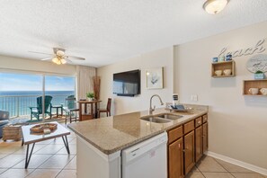 Enjoy meals in the kitchen with a dishwasher and sink, adjacent to a dining area with a table and chairs.