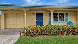 A two-story house with a blue door, a garage, and a covered porch.
