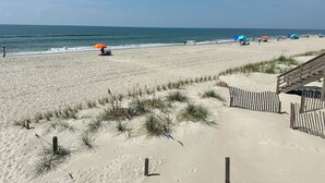 A sandy beach with a wooden walkway leading to a building. - Cozy 2BR - 2BA Condo - Ocean, Marsh & ICW Views • Pool & Private Dock • Sleeps 6 (Ocean Isle Beach)