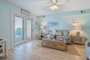 Un salon comprenant un canapé, une table basse, des lampes et un ventilateur de plafond.