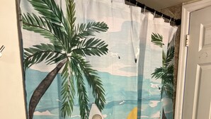 Een douchegordijn met surfplanken en palmbomen.