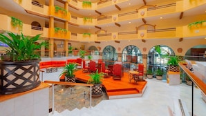 A multi-level atrium with seating areas, potted plants, and a central staircase. - Villa Del Palmar Cabo San Lucas Junior Suite /w Kitchen & View (Cabo San Lucas)