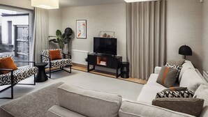 A modern living room with a sofa, armchair, and TV stand. - 3 bedroom accommodation in Croy, near Inverness (Croy, near Inverness)