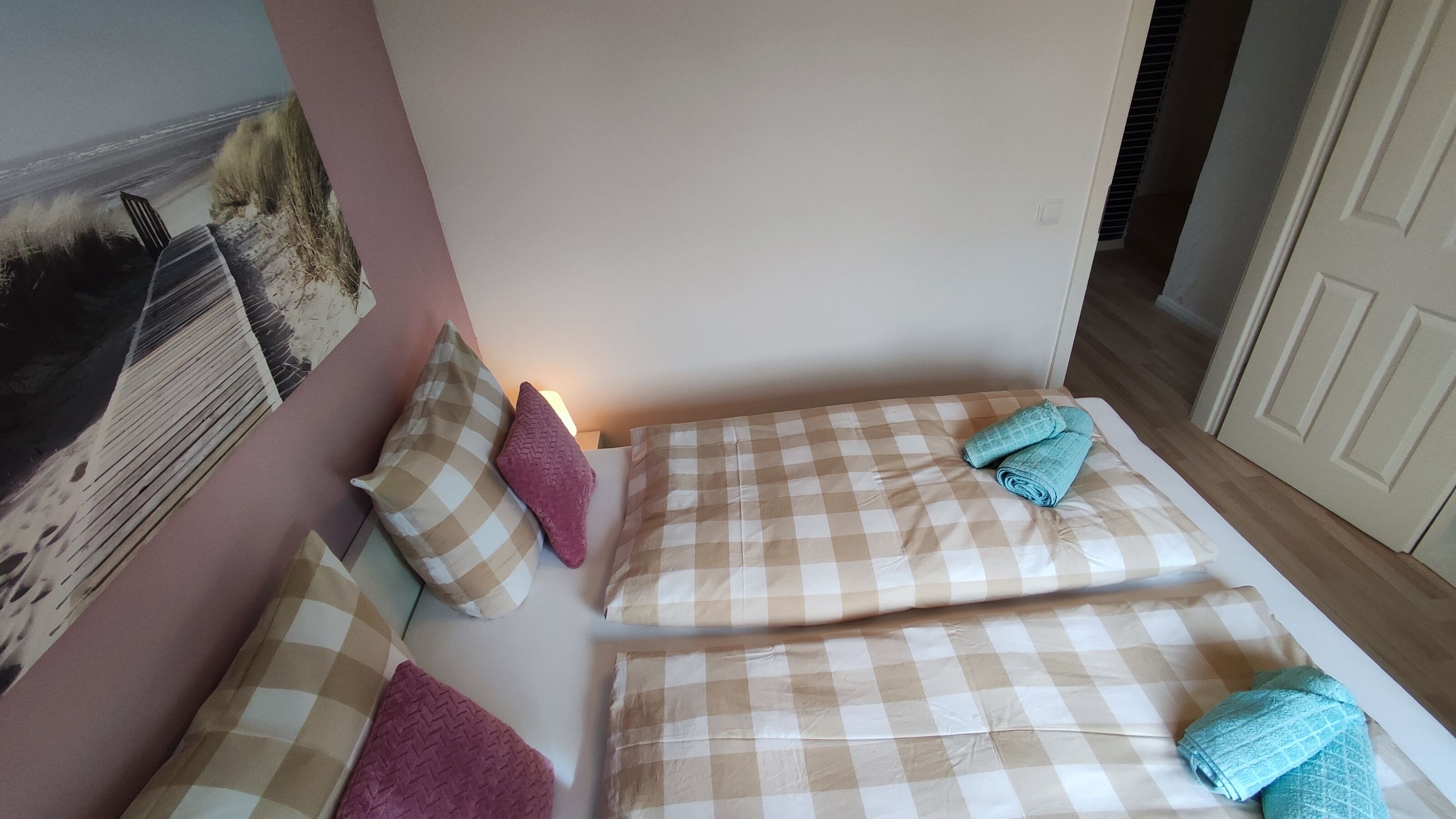 A bedroom with two beds, each with a checkered bedspread and pillows.