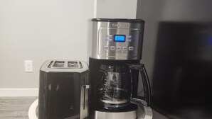 A kitchenette with a toaster, a coffee maker, and a refrigerator. - Spacious Basement Suite in Bonavista With Separate Entrance (Winnipeg)