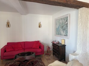 A living room with a red sofa, a wooden coffee table, a wooden dresser, and a framed painting on the wall. - Gite V.lac (Sainte-Croix-du-Verdon)