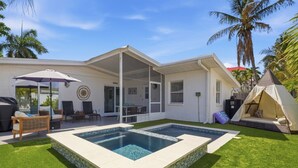 Una casa con piscina, mobiliario exterior y una tienda de campaña.