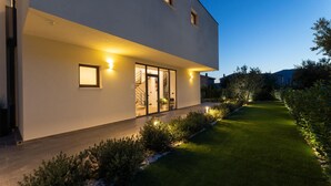 A modern two-story house with a well-maintained lawn and a pathway leading to the entrance. - Cozy home in Kastel Stari with sauna (Kastel Stari)