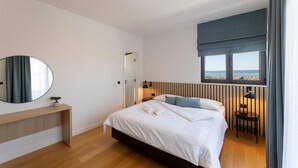 A modern bedroom with a bed, bedside tables, a mirror, and a window with a view. - Cozy home in Kastel Stari with sauna (Kastel Stari)