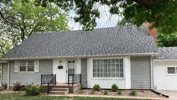 A single-story house with a gray roof, white siding, and a front porch with a black railing. - Updated family home in quiet neighborhood.   (El Dorado)