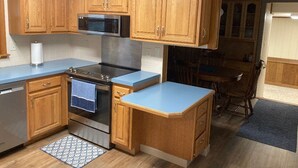 A kitchen with wooden cabinets, a microwave, an oven, and a blue countertop. - Updated family home in quiet neighborhood.   (El Dorado)