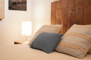 A bed with two pillows, a bedside lamp, and a wooden headboard.