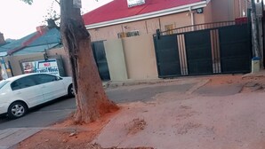 Un bâtiment avec un toit rouge, une entrée fermée par un portail et une enseigne indiquant qu’il s’agit d’une maison d’hôtes.
