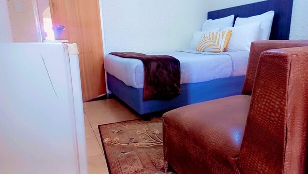 Une chambre à coucher avec un lit, une chaise et une porte en bois.