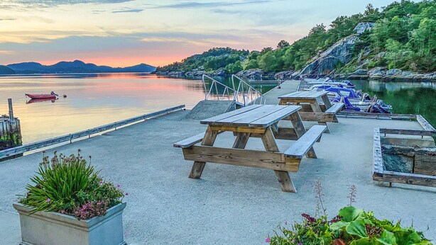 A lakeside picnic area with wooden benches and a dock. - Gorgeous home in Skjold (Skjold)