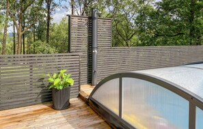 Relax by the pool surrounded by lush greenery and a tranquil atmosphere.