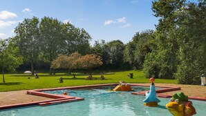 A swimming pool with colorful sculptures and a grassy area with trees. - Nice home in Heinkenszand with WiFi (Heinkenszand)