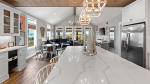 A modern kitchen with white cabinetry, a large island, and a wooden ceiling. - Steps from Beach: Sleeps 15, Hot Tub, Pet-Friendly (Crystal Beach)