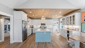 A modern kitchen with white cabinetry, a central island, and a wooden ceiling. - Steps from Beach: Sleeps 15, Hot Tub, Pet-Friendly (Crystal Beach)