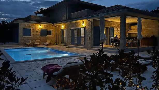 A poolside area with a swimming pool, lounge chairs, and a covered patio with outdoor seating. - Stunning home in Pifari (Pifari)