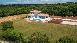 A two-story house with a tiled roof, a swimming pool, and a fenced yard. - Stunning home in Pifari (Pifari)