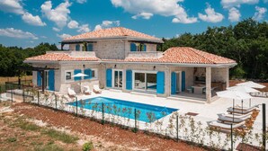 A two-story house with a swimming pool, outdoor seating, and a covered patio area. - Stunning home in Pifari (Pifari)