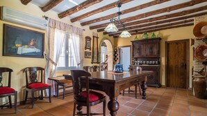 A rustic dining area with a wooden table, chairs, and a tiled floor. - 4 bedroom awesome home in Arriate (Arriate)