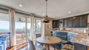 Una cocina amplia con una mesa redonda, armarios oscuros y vistas al exterior.