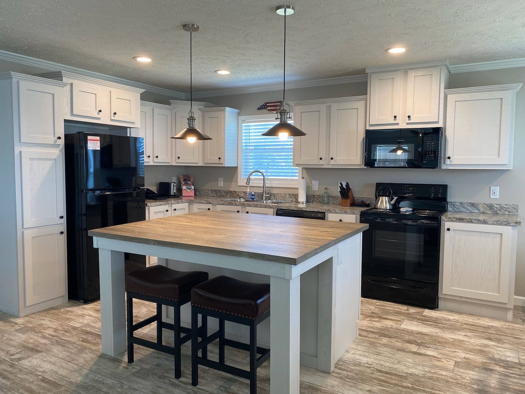 Large, open kitchen with island/seating and adjacent water view dining area.