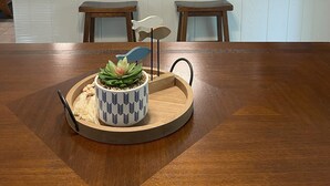 Cozinha moderna com armários de madeira, uma geladeira branca, micro-ondas e uma ilha grande com banquetas.