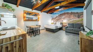 A modern interior with a kitchen, dining area, and a bedroom with a mountain mural. - Hansen Inn and Cabins (Wall)