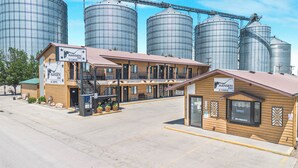 A Hansen Inn & Cabins with a two-story structure, a front entrance, and a small annex building. - Hansen Inn and Cabins (Wall)