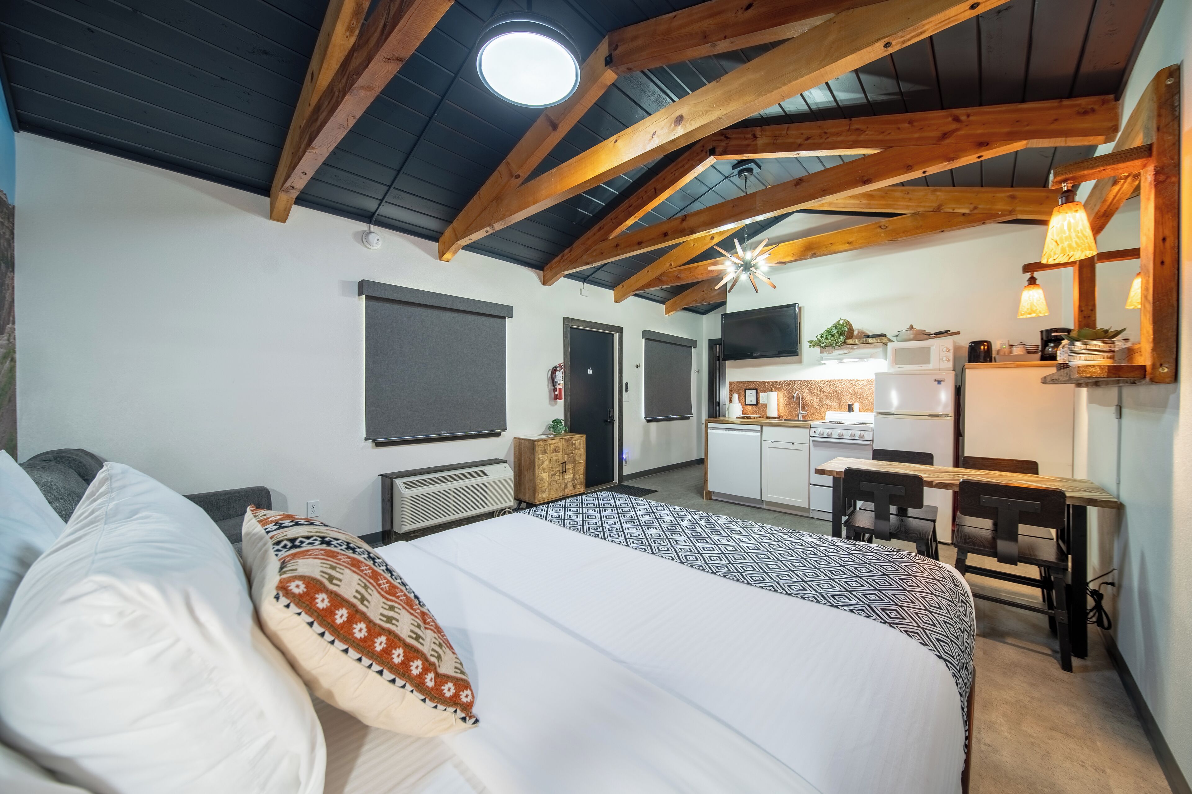 Ein Schlafzimmer mit einem großen Bett, einem Schreibtisch und einer Küchenzeile.