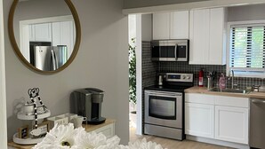 A modern kitchen with white cabinets, stainless steel appliances, and a wooden countertop. - Red Cabin Lake House with Amazing Views! (Vernon Township)